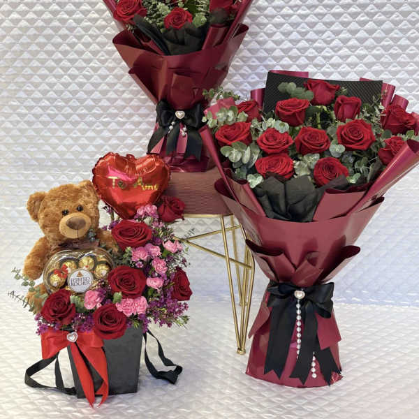 Three red rose bouquets with a teddy bear and chocolates