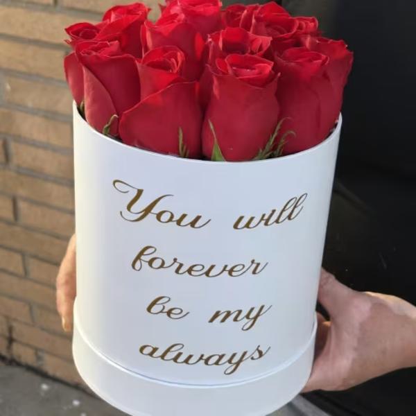 Red roses in a white hat box with gold text