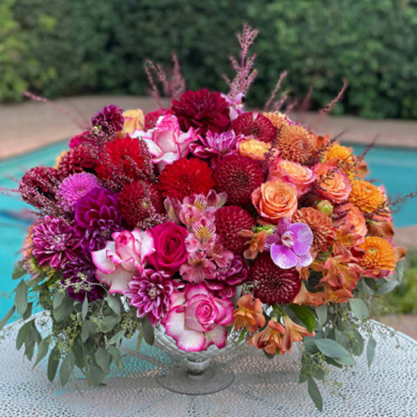 Colorful mixed bouquet in a clear glass compote vase