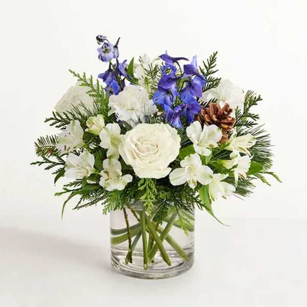 White and blue floral arrangement in a clear glass vase