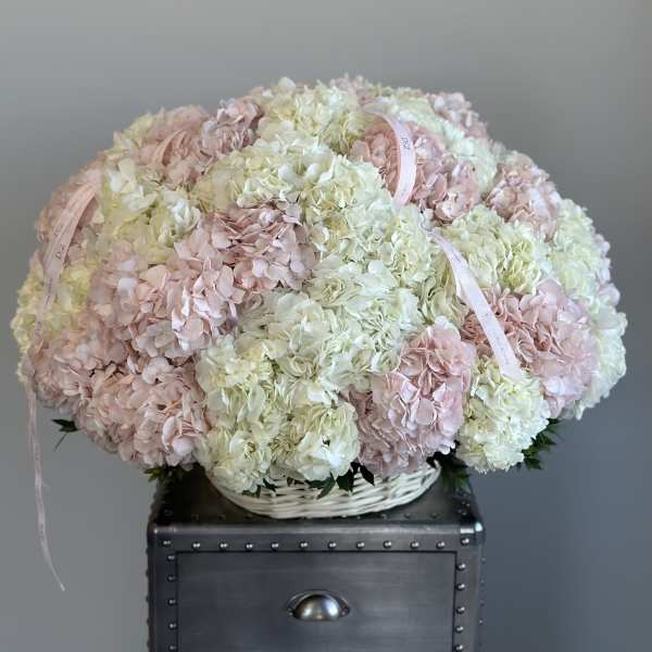 Large pastel hydrangea arrangement in a white basket