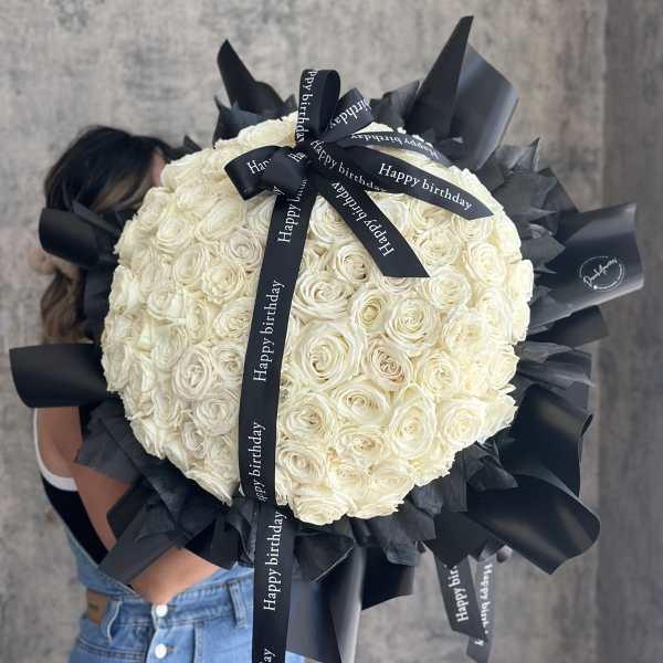 Large bouquet of white roses wrapped with black ribbon
