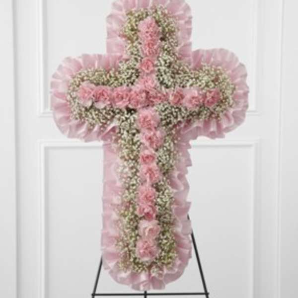 Pink floral cross-shaped standing spray on an easel