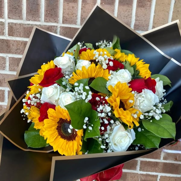 Bouquet of sunflowers, red and white roses, and baby's breath in black wrap