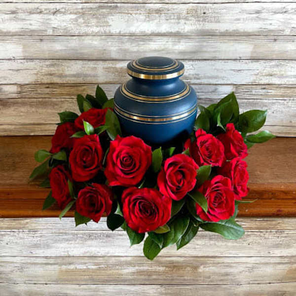 Red roses arranged around a blue urn