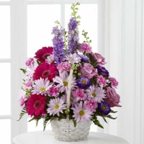 Pink and purple mixed flowers arranged in a white basket