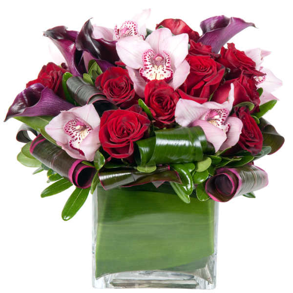 Bouquet of red roses and pink orchids in a glass vase