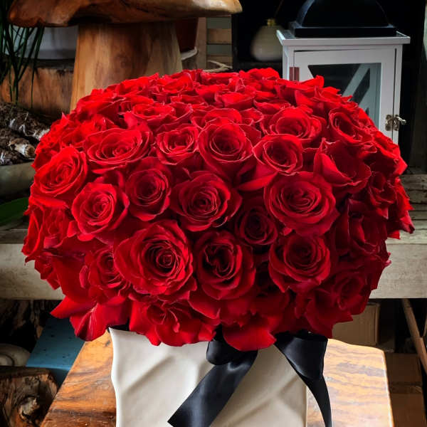 Large bouquet of red roses in a white box with a black ribbon