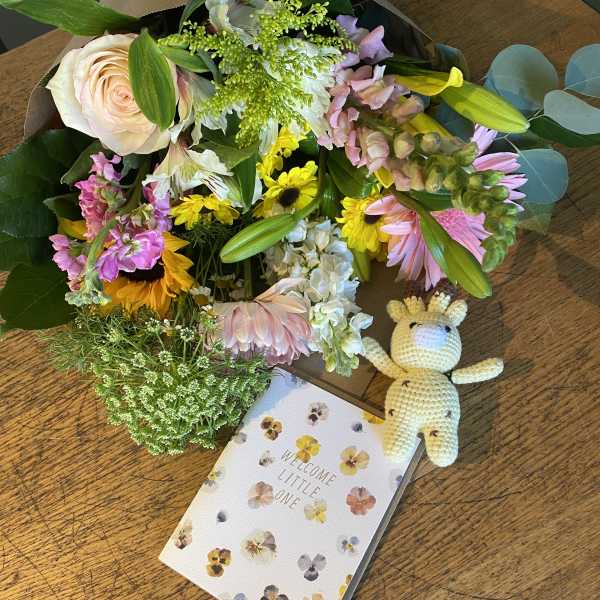 Mixed pastel bouquet with a crocheted giraffe and a welcome card