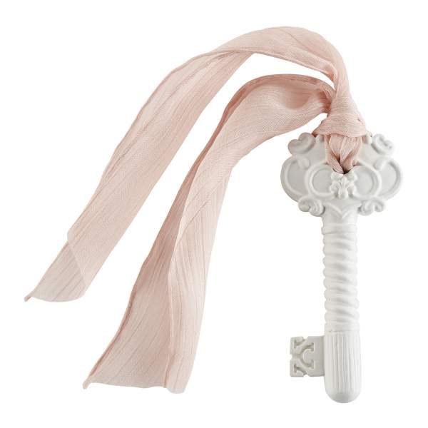 Decorative white key with a pale pink ribbon tied through it