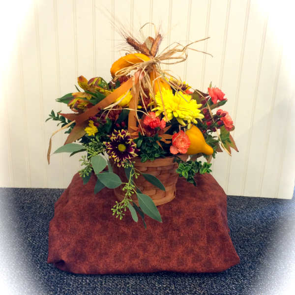 Autumn flower basket with yellow and orange blooms and pumpkins