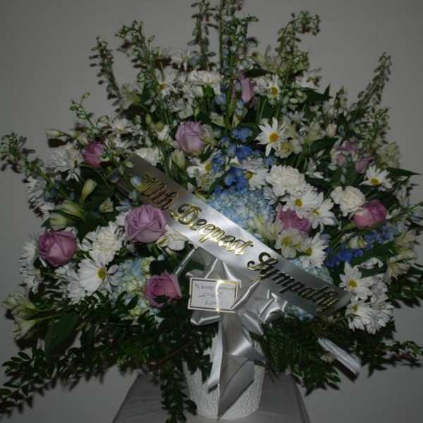 Large sympathy spray with pink roses, white daisies, and blue flowers