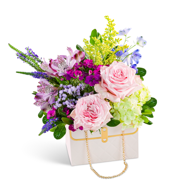 Pink roses and mixed flowers in a white handbag-shaped box