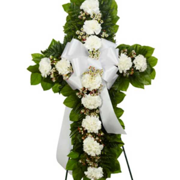White floral standing cross with ribbon on an easel