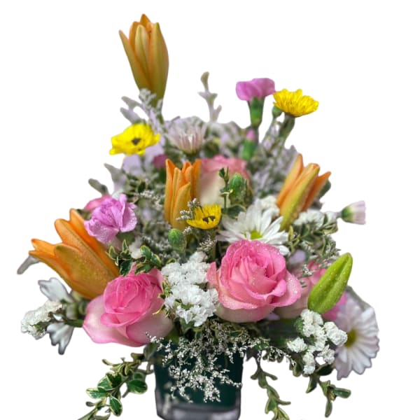 Pink roses and mixed flowers in a small square vase