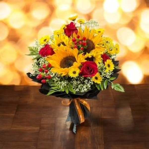 Bouquet of sunflowers and red roses with a black wrap and ribbon