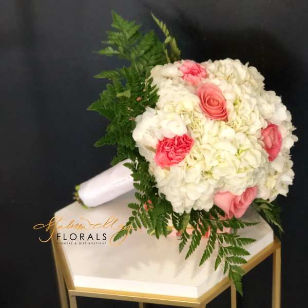 Pink and white bouquet with fern foliage on a white box