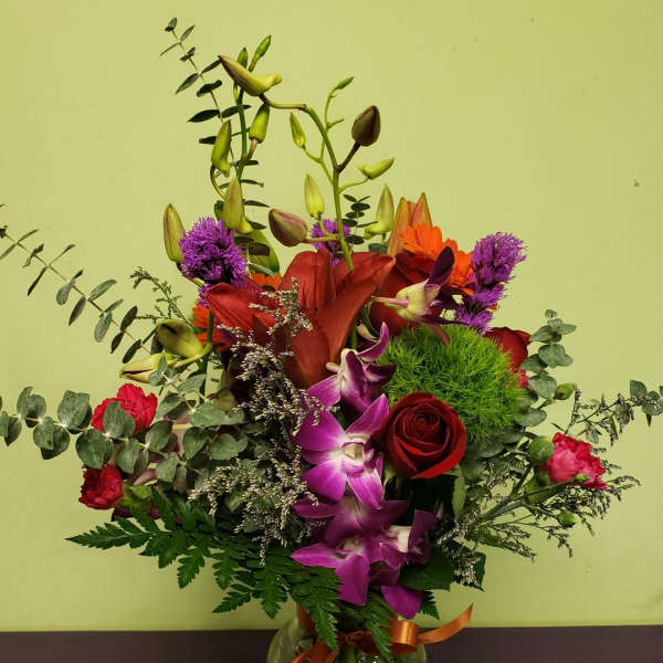 Mixed bouquet in a glass vase with red, purple, and orange flowers