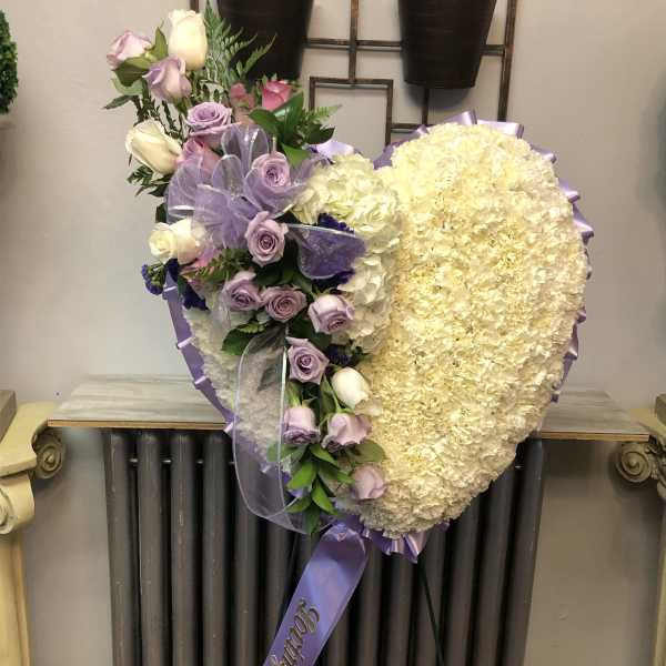 Heart-shaped floral spray with lavender roses and cream blooms on a stand