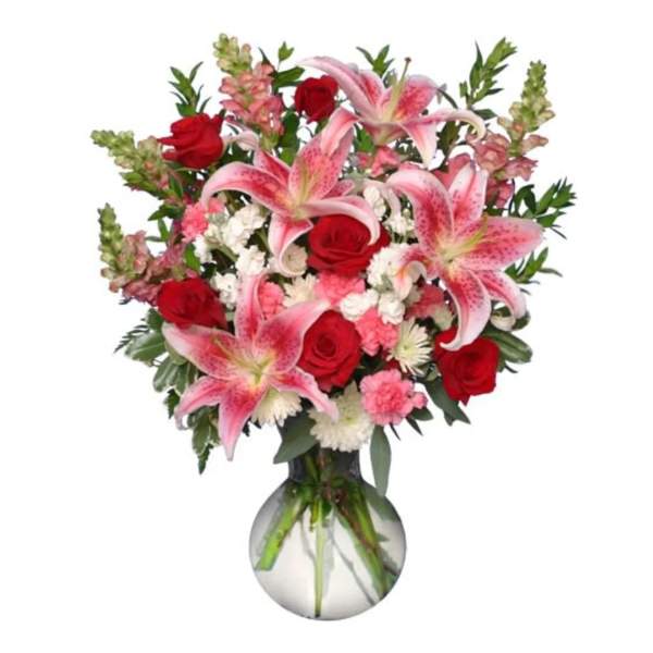 Bouquet of pink lilies and red roses in a glass vase
