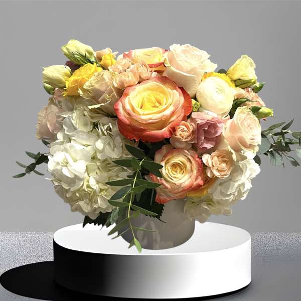 Bouquet of pastel roses and hydrangeas in a white vase