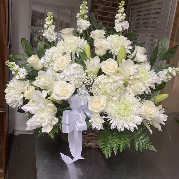 White floral basket arrangement with roses, lilies, and chrysanthemums