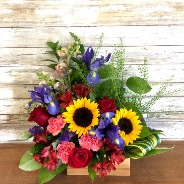 Mixed bouquet with sunflowers, red roses, purple irises, and pink carnations