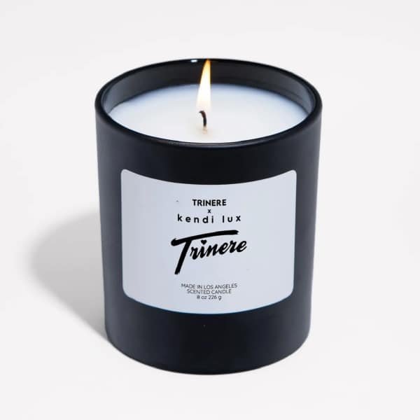 Lit black scented candle in a glass jar with a white label
