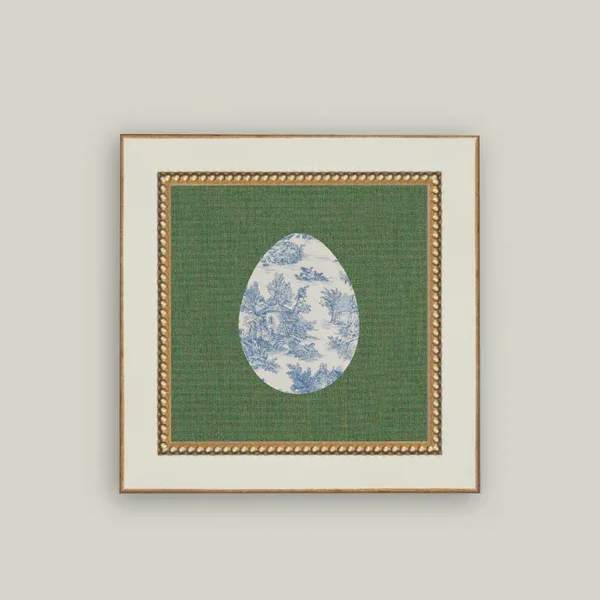 Framed decorative print with a blue-and-white egg motif on green fabric