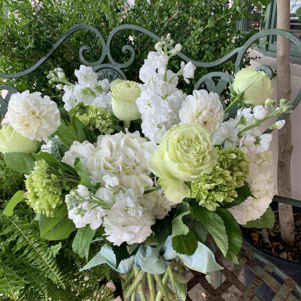 White and pale green bouquet in a clear glass vase
