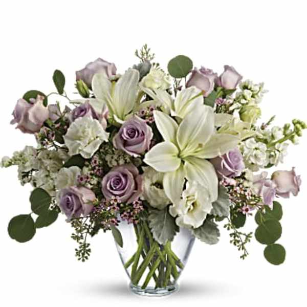 Lavender roses and white lilies in a clear glass vase