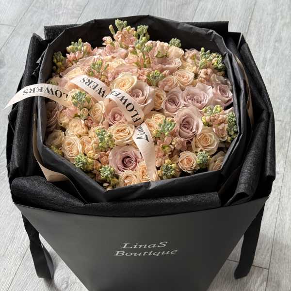 Bouquet of blush and peach roses in a black gift box