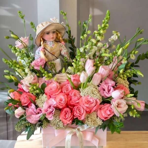 Pink rose bouquet with a doll centerpiece in a pink box
