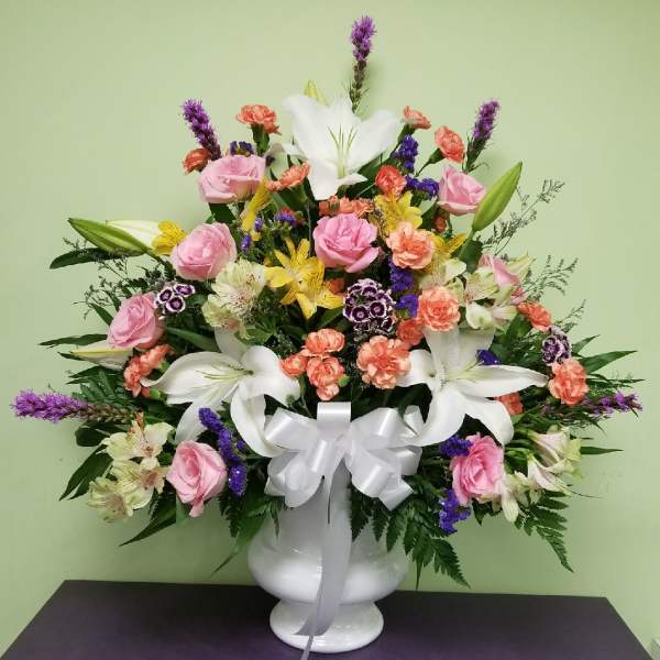 Mixed bouquet in a white vase with pink roses and white lilies