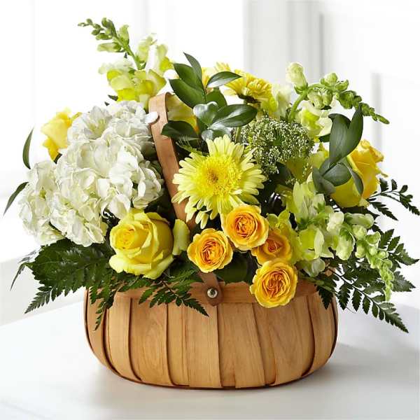Yellow and white flower arrangement in a wooden basket