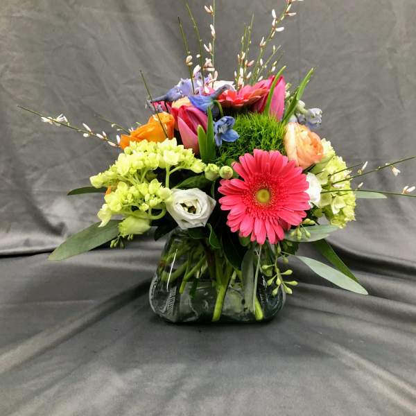 Colorful mixed bouquet in a glass vase with a pink gerbera daisy