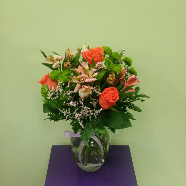 Orange roses and pink alstroemeria in a glass vase