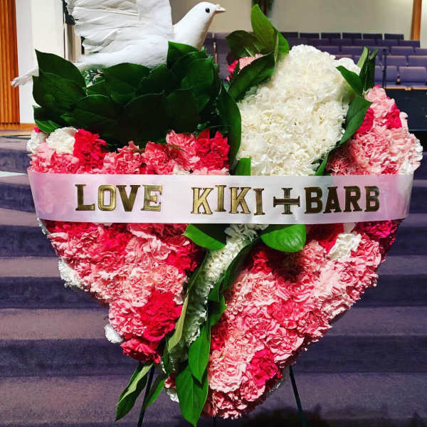 Heart-shaped pink and white carnation tribute with a white dove