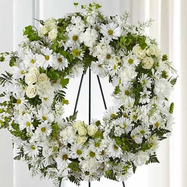 White floral wreath on a black stand