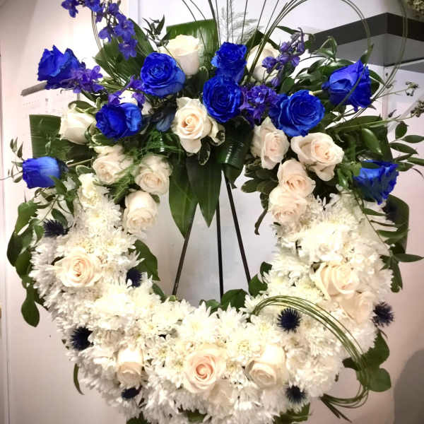 Large heart-shaped floral wreath with blue and white roses