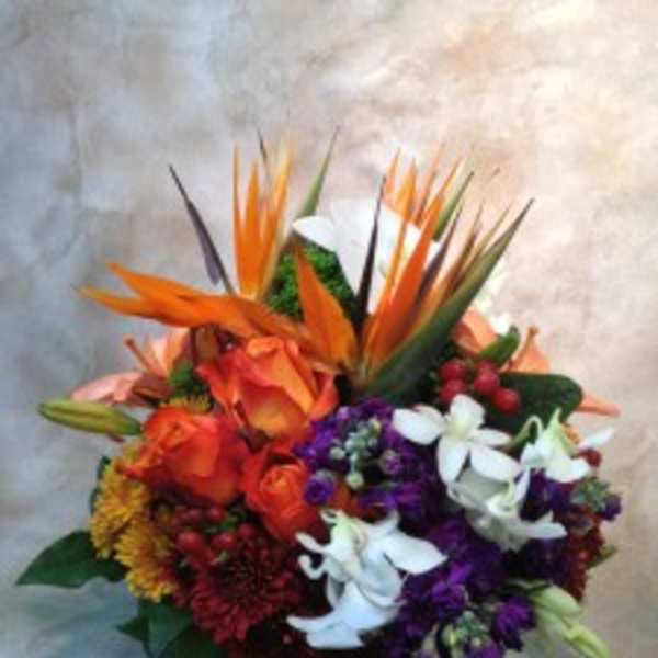 Tropical bouquet with orange birds of paradise and mixed flowers