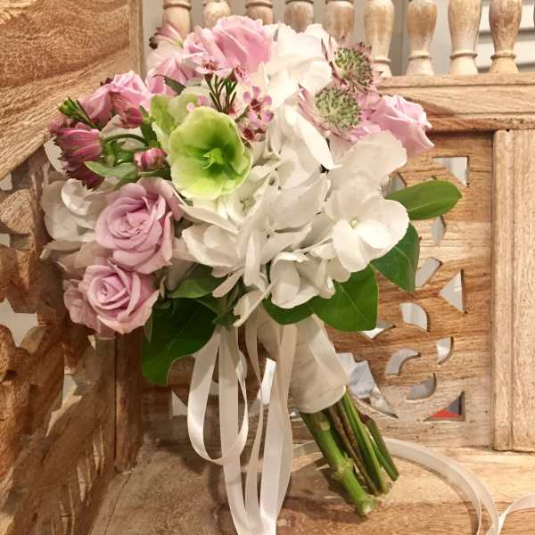 Pink and white bouquet with roses and hydrangeas tied with white ribbon