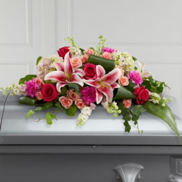 Pink and white floral casket spray with roses and lilies