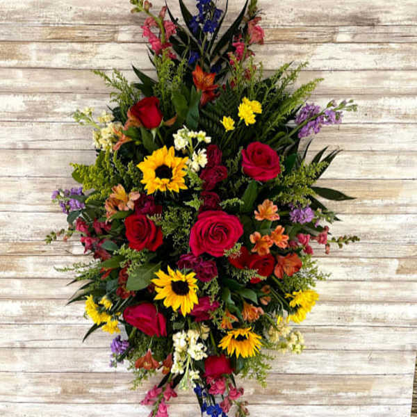 Tall mixed bouquet with red roses, sunflowers, and purple flowers