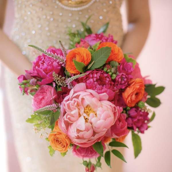 Bride holding a bright pink and orange bouquet