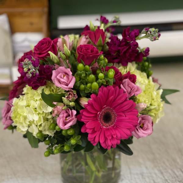 Bouquet of pink and magenta flowers in a clear glass vase