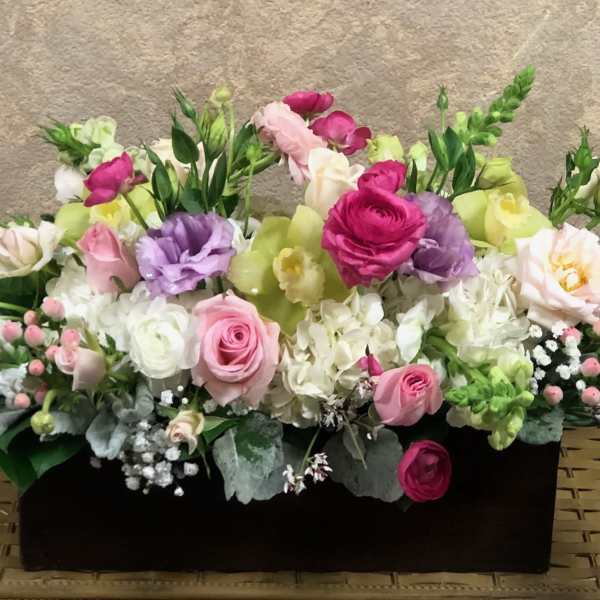 Mixed pink, white, and purple flowers in a black rectangular container