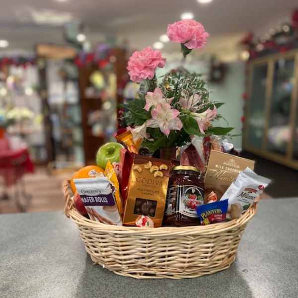 Gift basket with pink flowers and assorted snacks