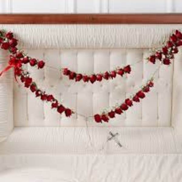 Red floral garlands draped across a white upholstered headboard