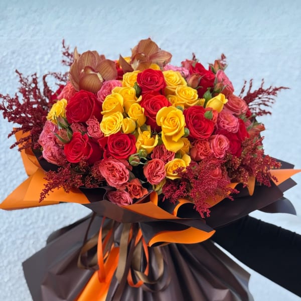 Bouquet of red and yellow roses wrapped in brown and orange paper